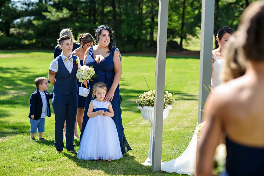 A wedding party watches as a lesbian couple exchange their vows.